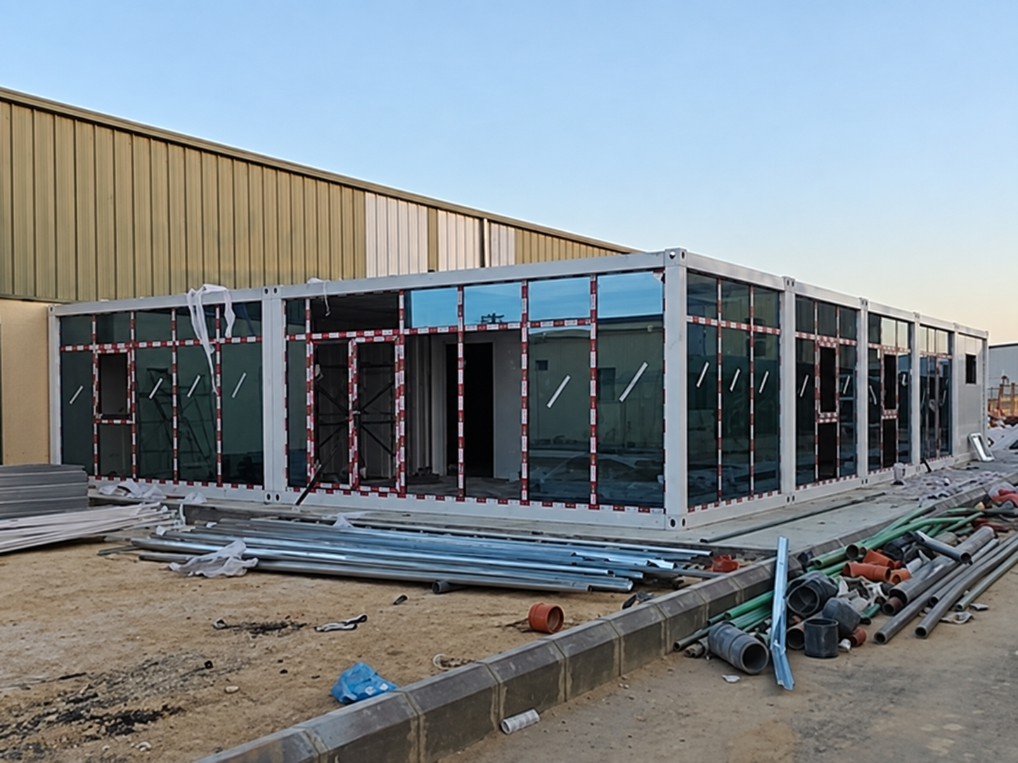Partly glazed ground-floor container office beside the Riyadh workshop