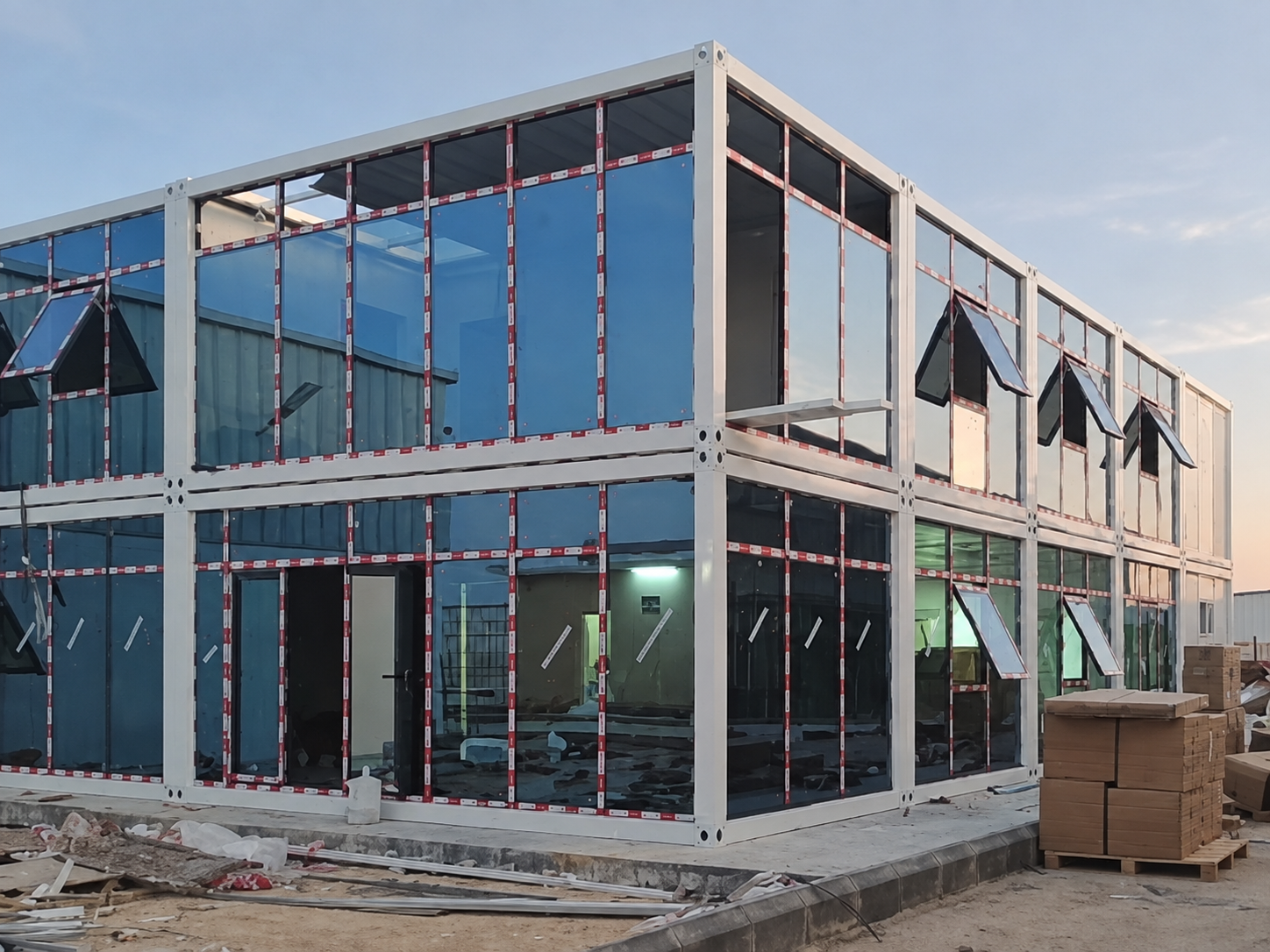 Two-storey modular container office in Riyadh with glazed front and side facades during assembly
