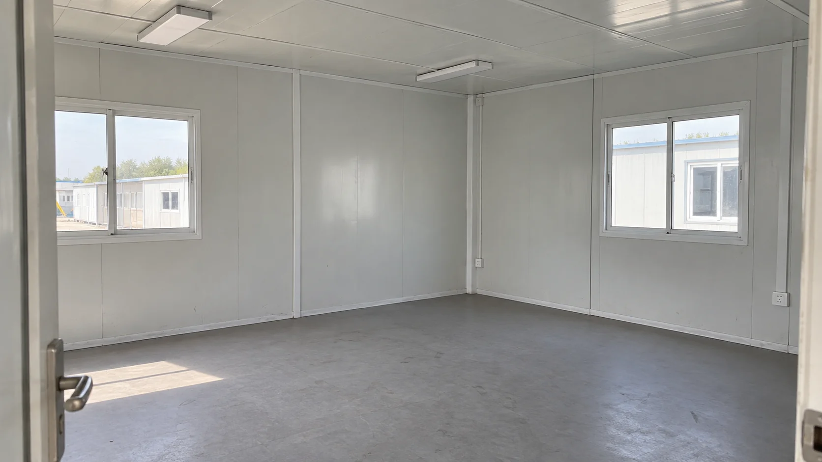 Illustrative prefab office interior with panel walls, windows, lighting and electrical fittings