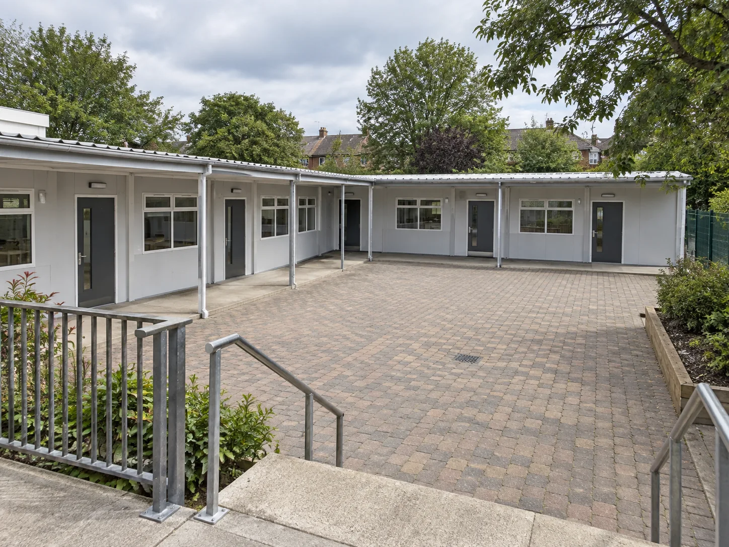 Modular classroom block overlooking a paved school courtyard