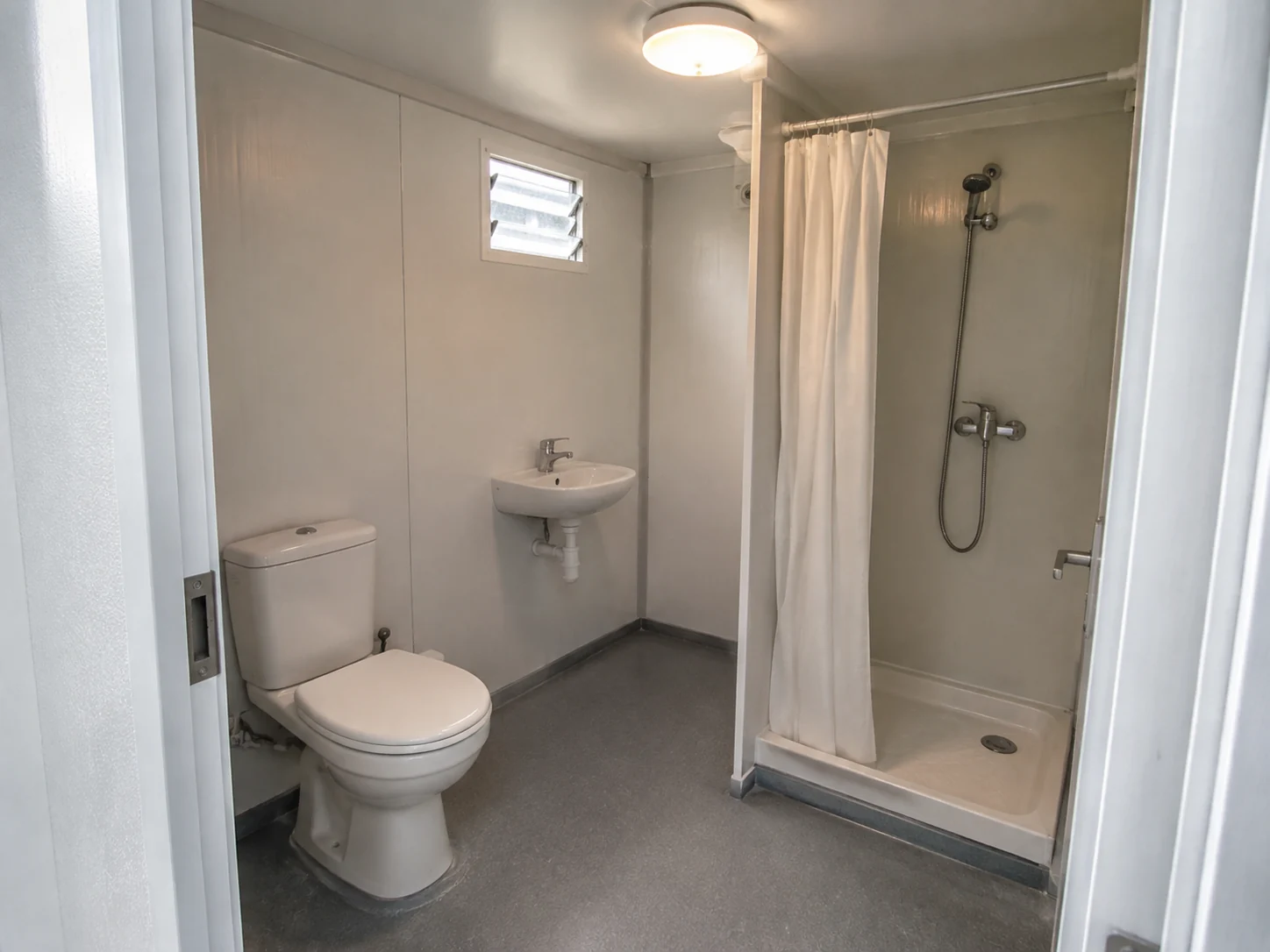 Illustrative combined bathroom with toilet, basin and a separate shower area