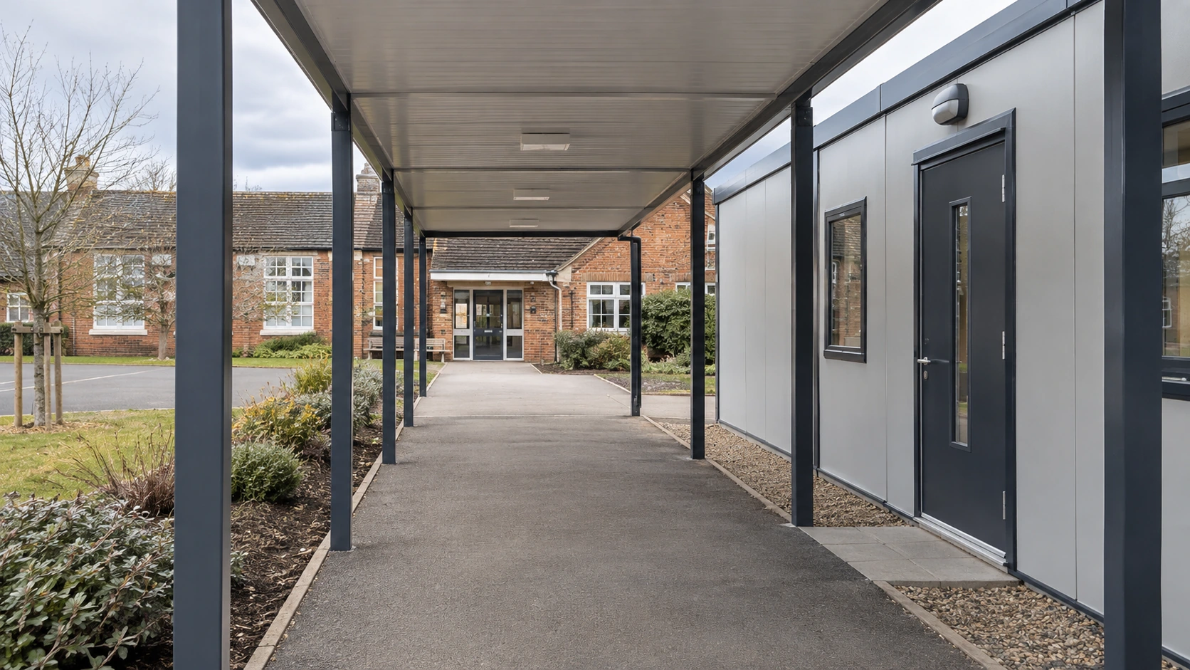 New concept illustration of a covered pedestrian connection between a modular classroom and an existing school building.
