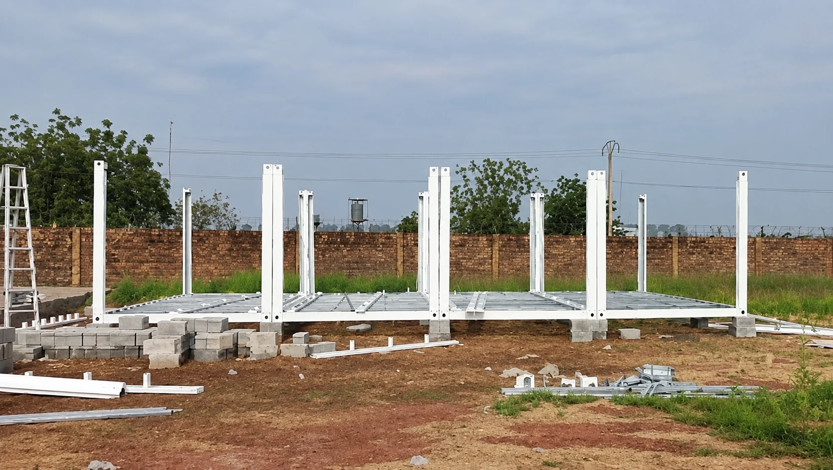 White steel posts standing on modular floor frames across the site
