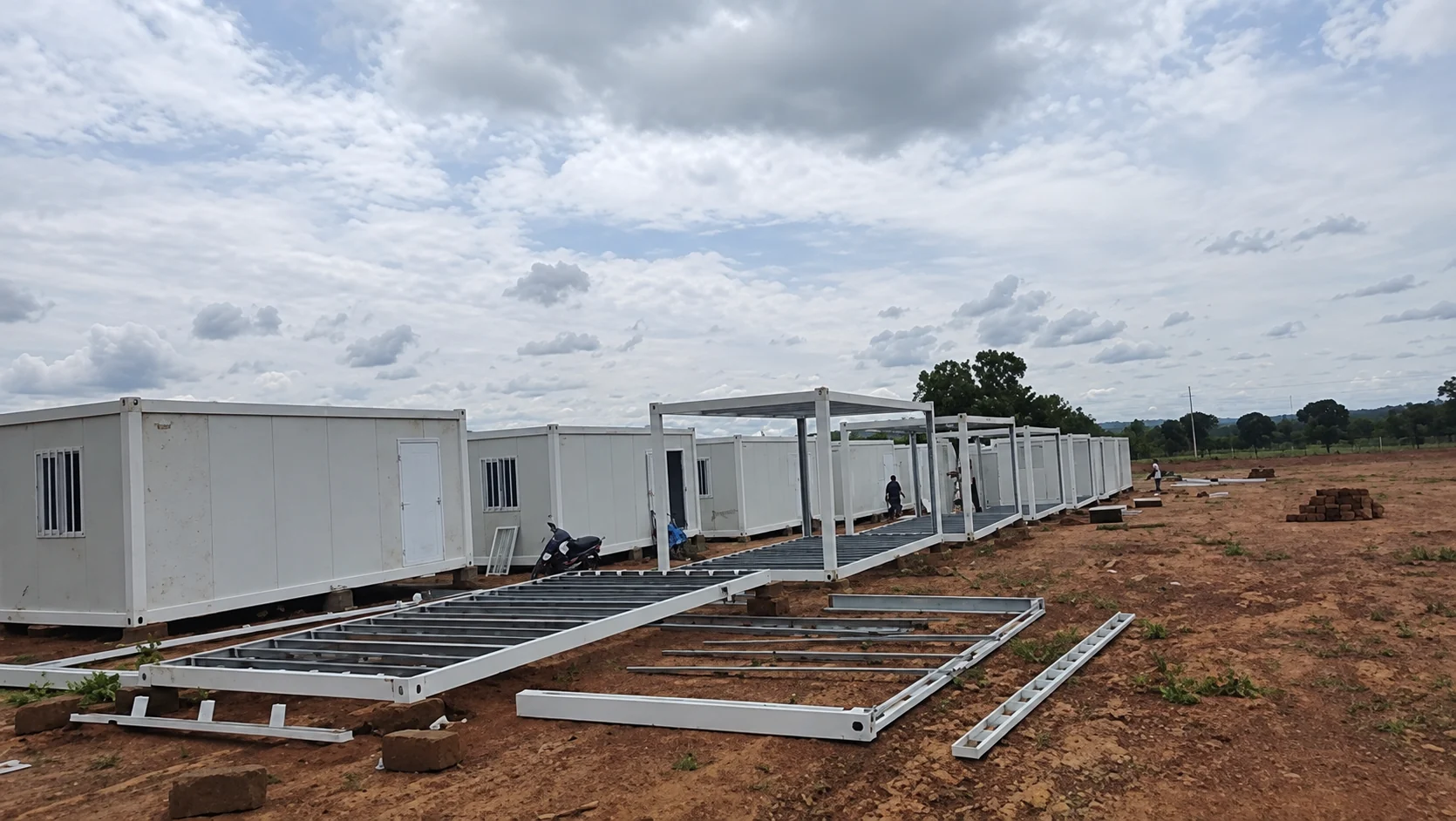 Partially enclosed white cabins aligned in a row during construction