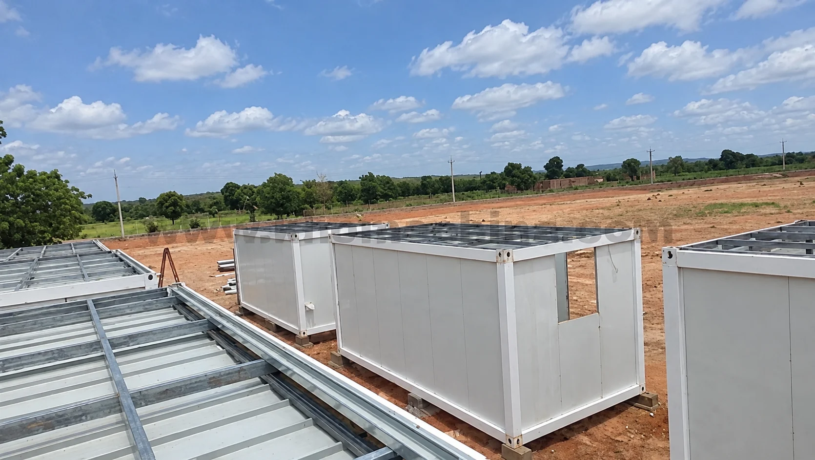 Roof view over white cabins being assembled at the site
