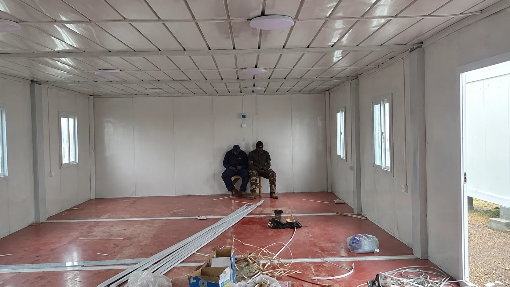 Two workers inside a modular room during interior fit-out
