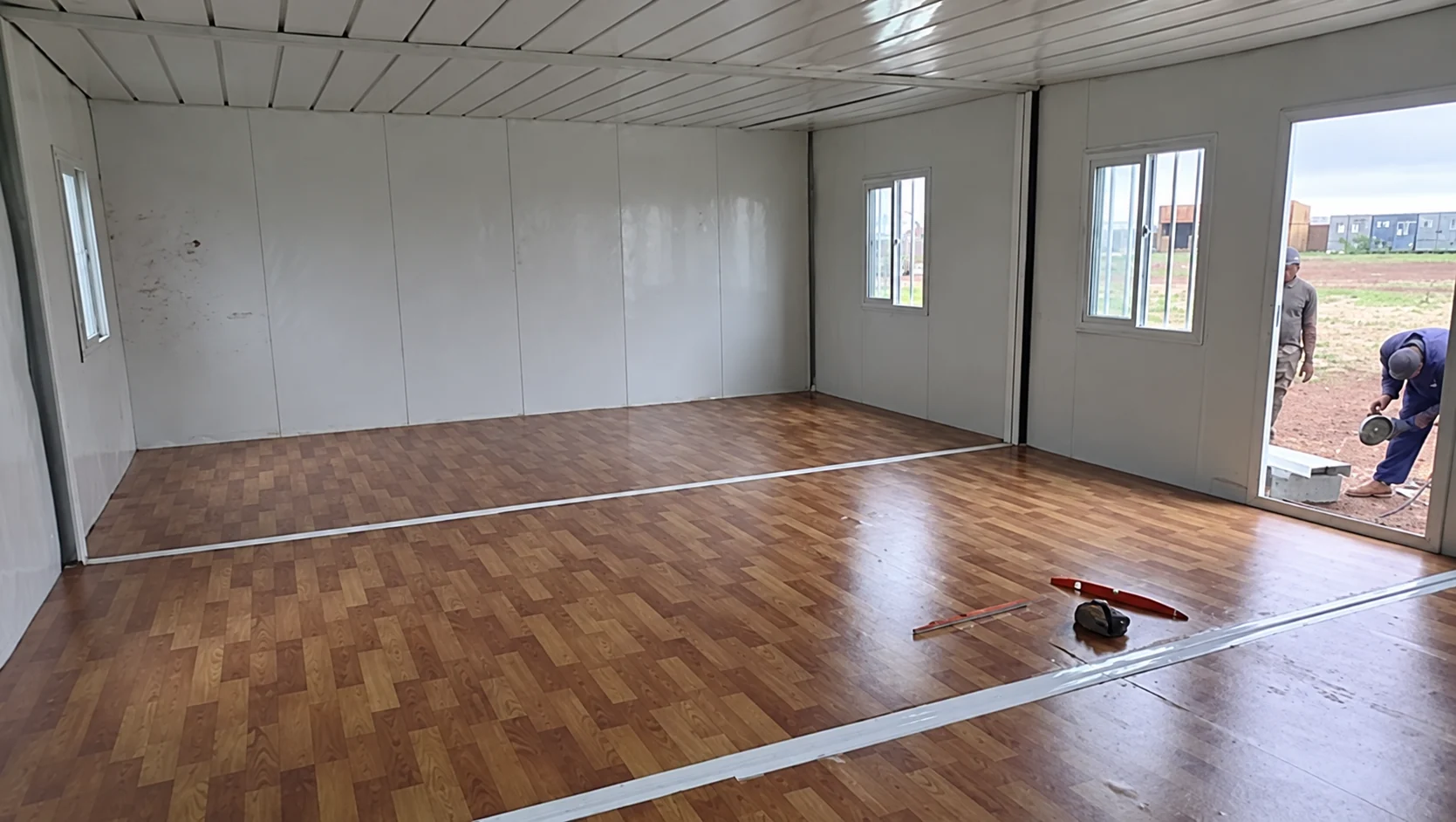 Wide modular interior with wood-look flooring and windows