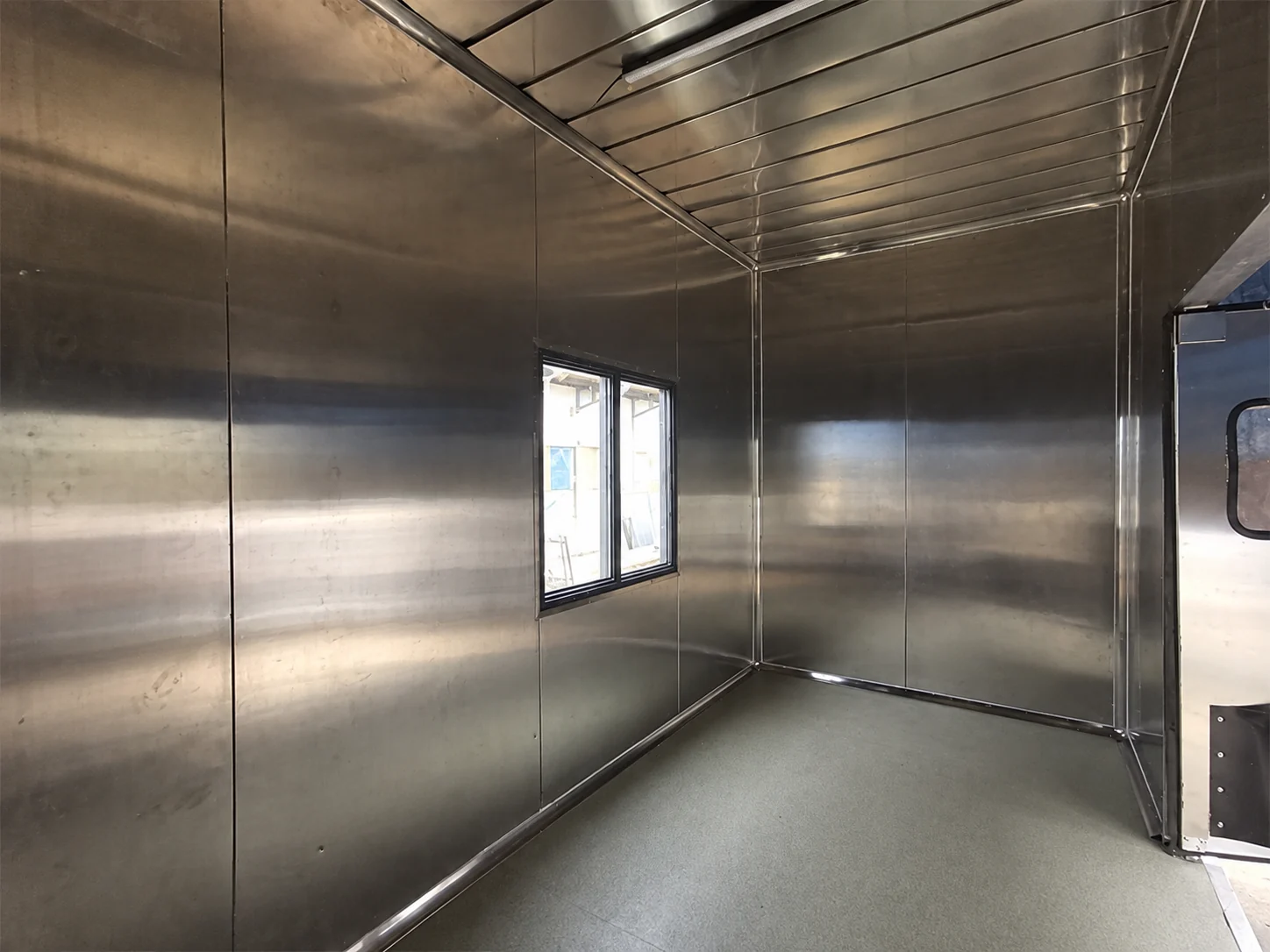 Stainless-lined interior of the compact service module with a window