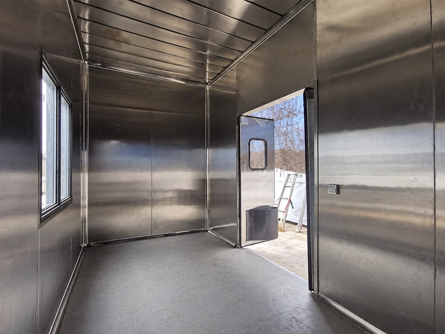 Stainless-lined service module interior showing a door and window