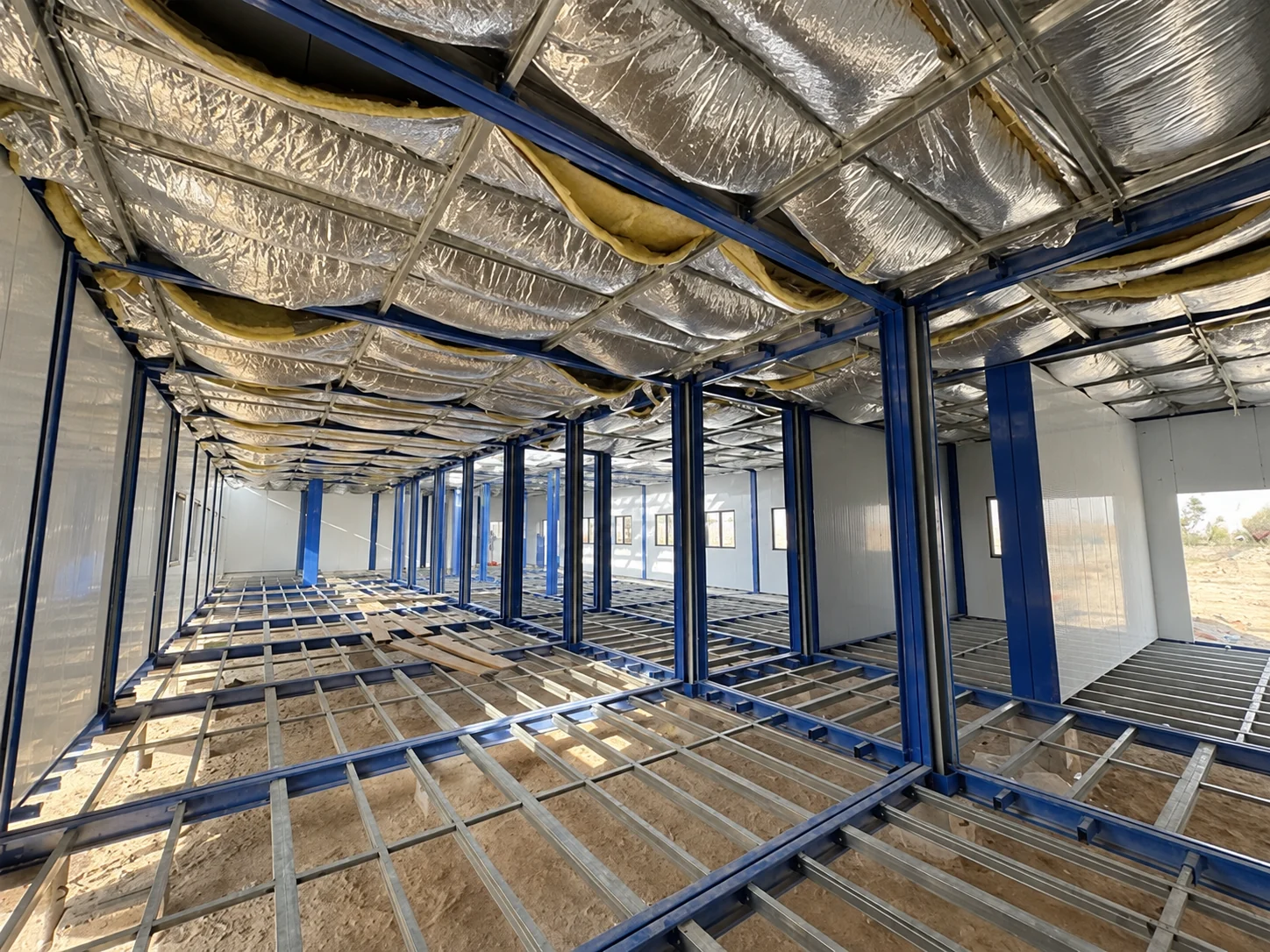 Connected modular interior showing roof insulation and an unfinished floor