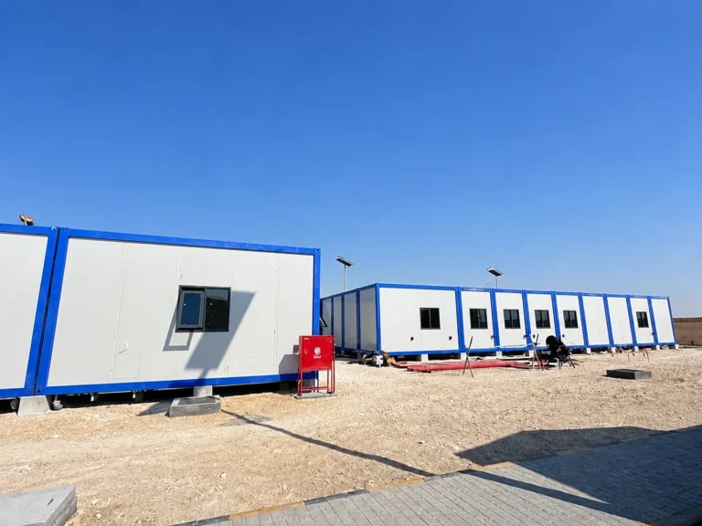 Row of white modular cabins with blue edges at the Oman welfare site