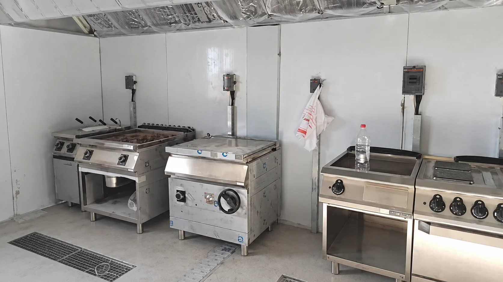 Commercial cooking equipment positioned in a modular kitchen room