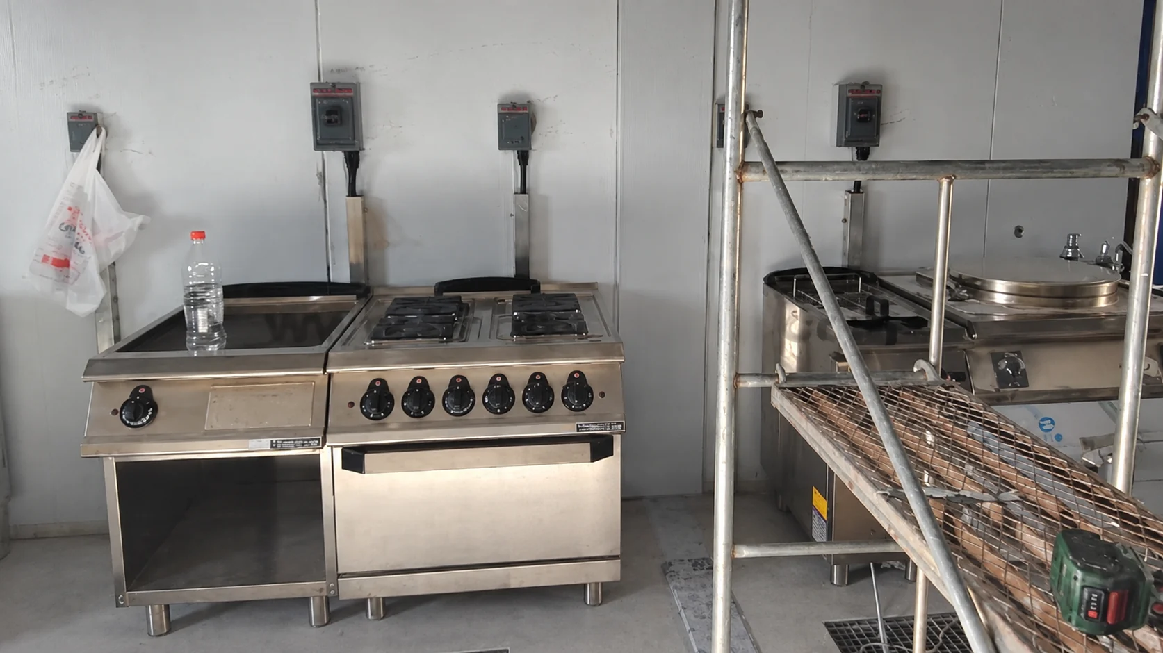 Commercial cooktop beside a stainless steel preparation counter