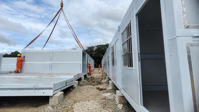 Crane lifting a white folding module at the Philippine mining-site project