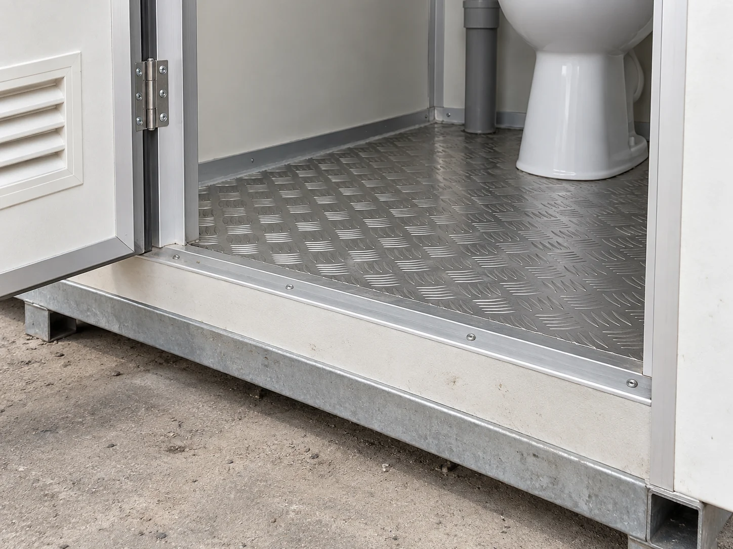 Illustrative detail of a portable toilet threshold, metal floor and panel junction