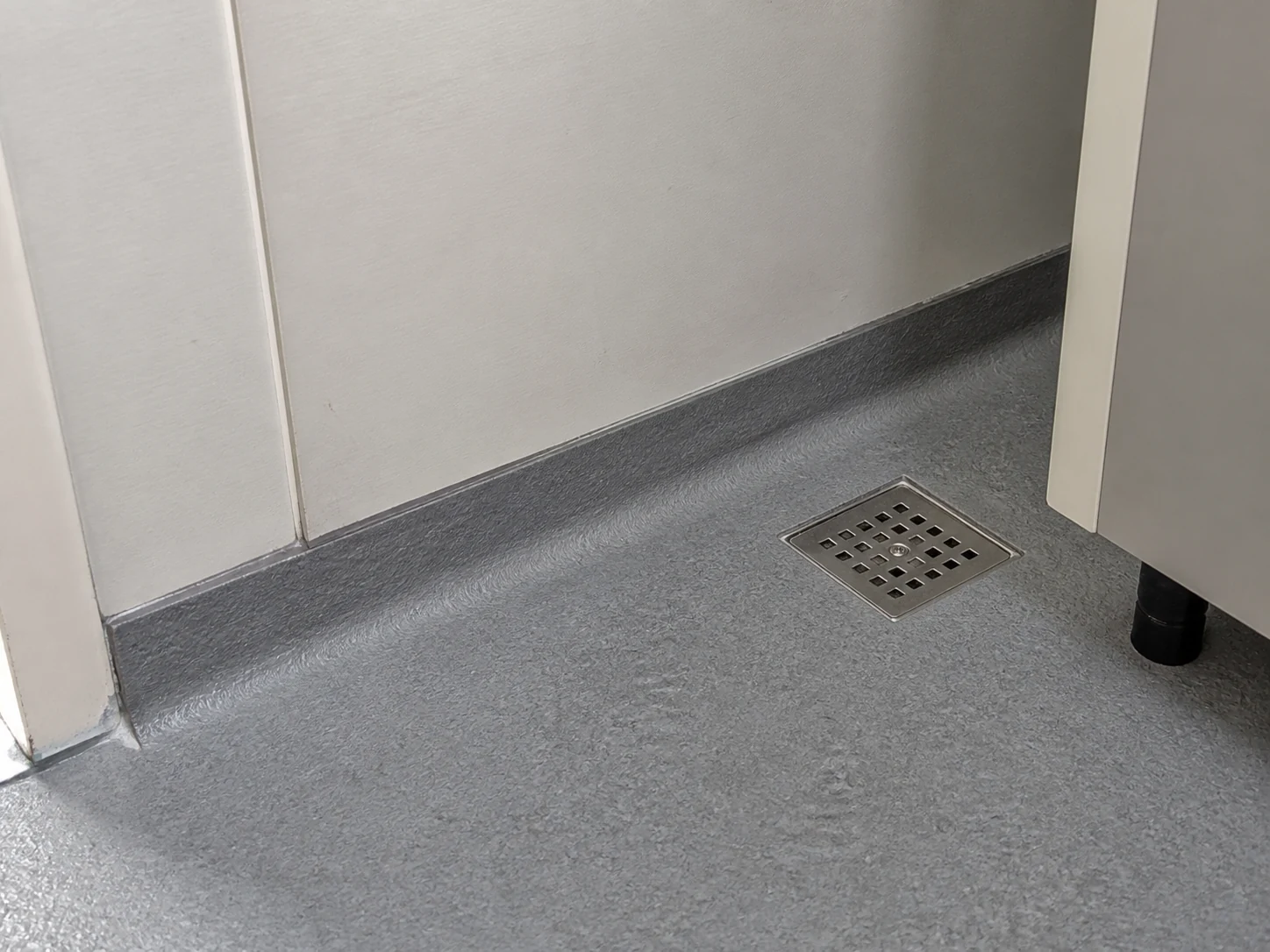 Illustrative wet-area floor drain, wall junction and partition detail