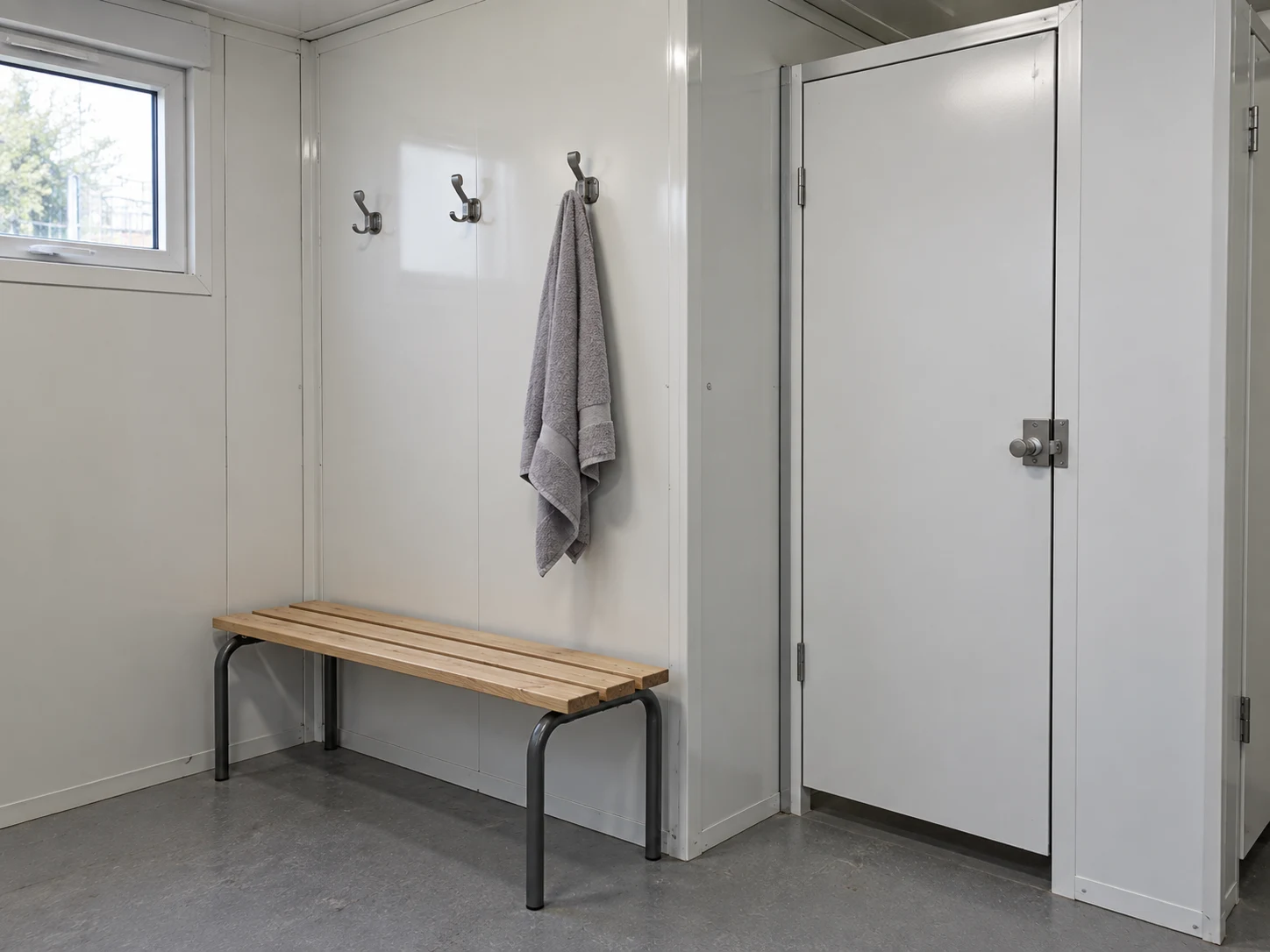 Illustrative shower changing space with a bench, hooks and privacy door
