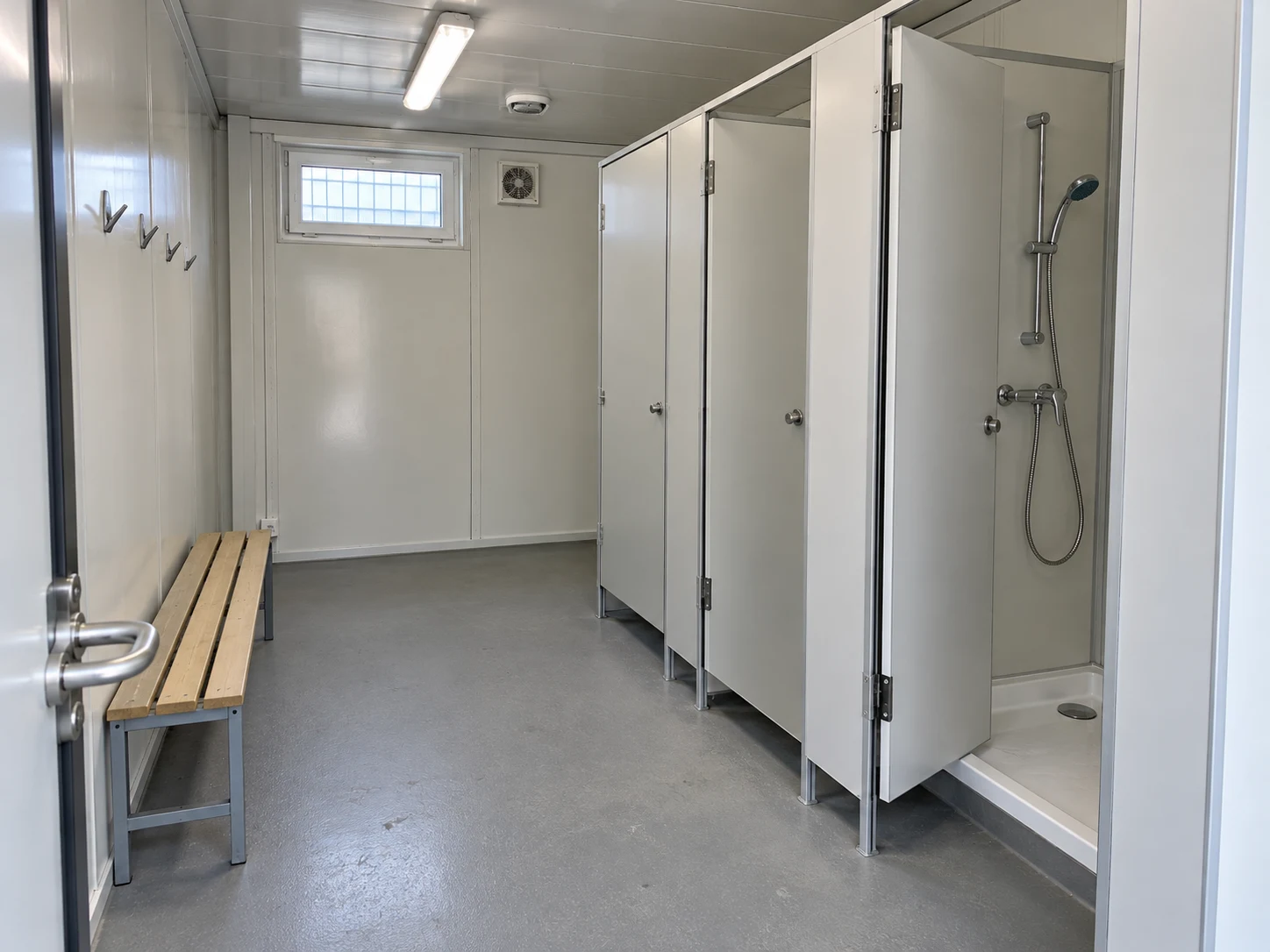 Illustrative shower block interior with private cubicles and a changing bench