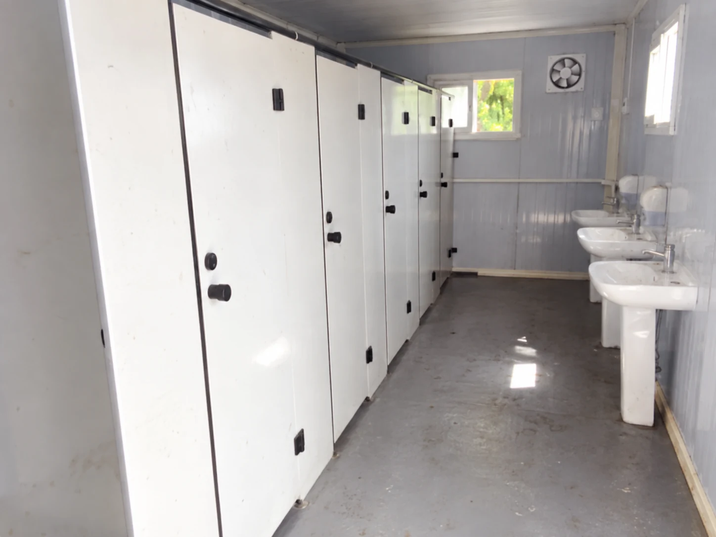 Reference washroom interior with toilet cubicles and washbasins