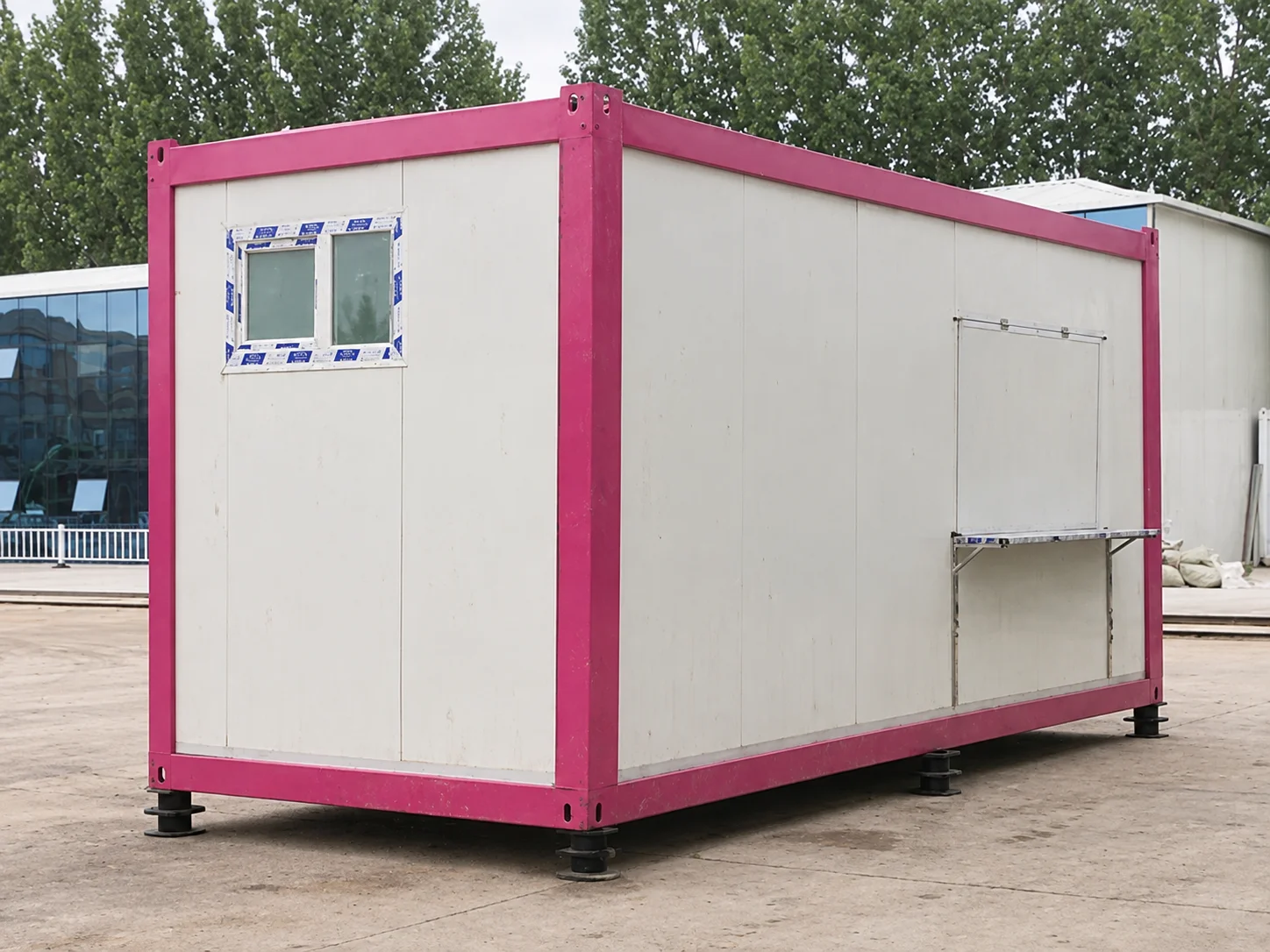 Reference pink-framed modular cabin with a window and closed service hatch