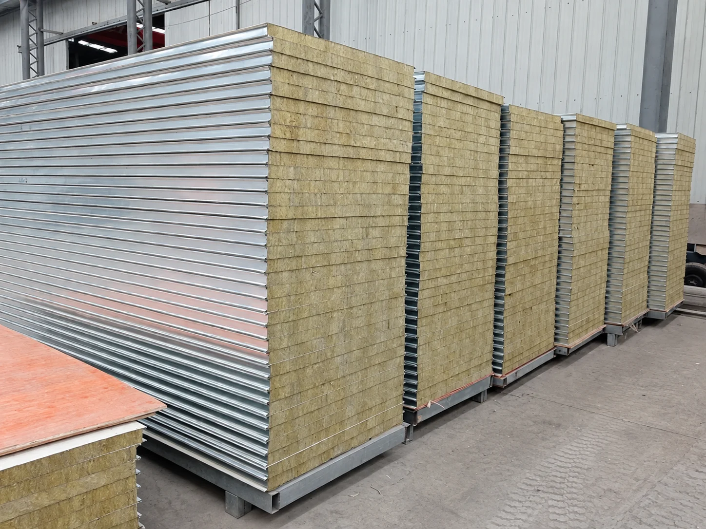 Workshop reference showing stacks of white-faced panels with exposed fibrous edges