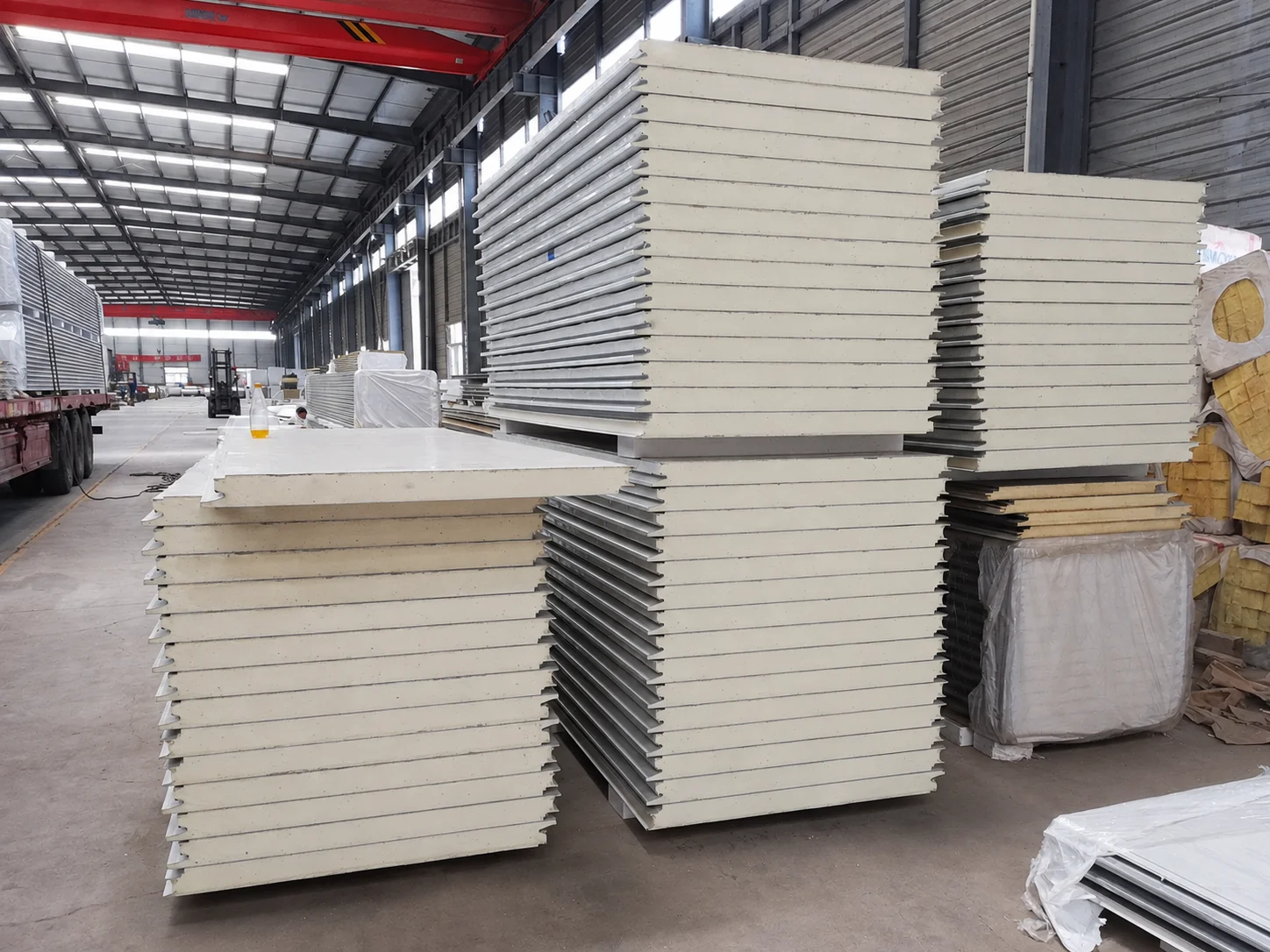 Workshop reference showing stacks of wall panels inside a production building