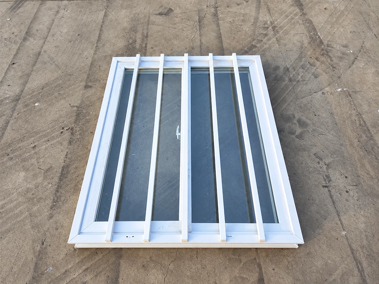 Reference barred window frame laid on a concrete floor