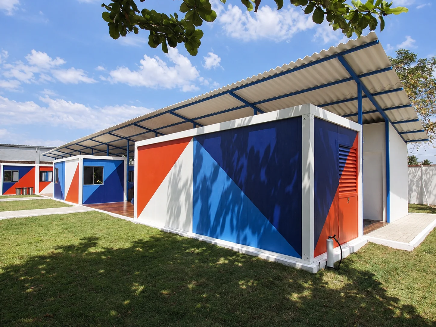 Reference blue-and-red cabins beneath a shared canopy