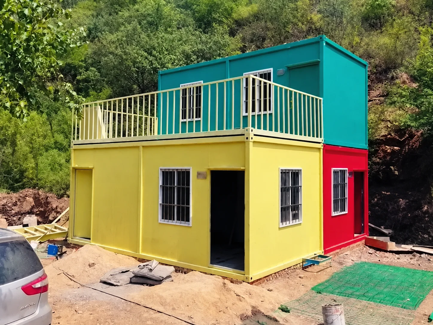 Reference brightly coloured stacked modular rooms with a terrace railing