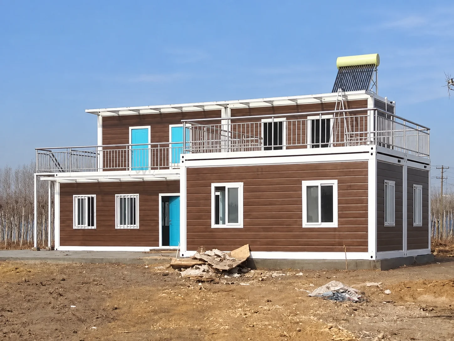 Reference brown-and-white modular building with a terrace railing