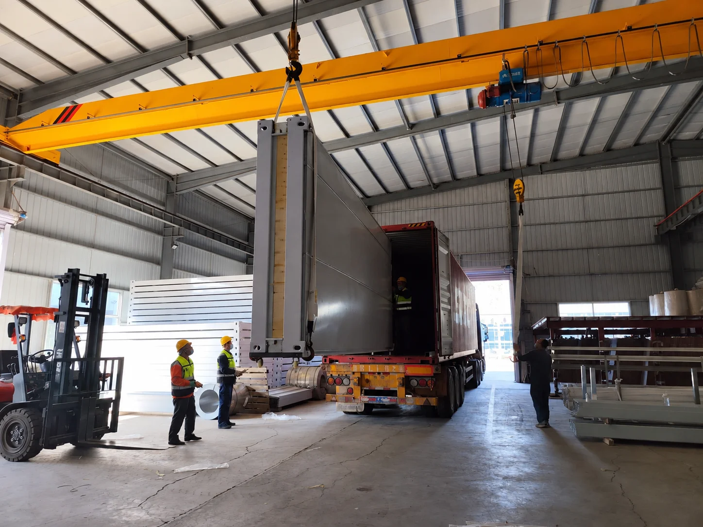 Workshop reference showing workers beside an open shipping container