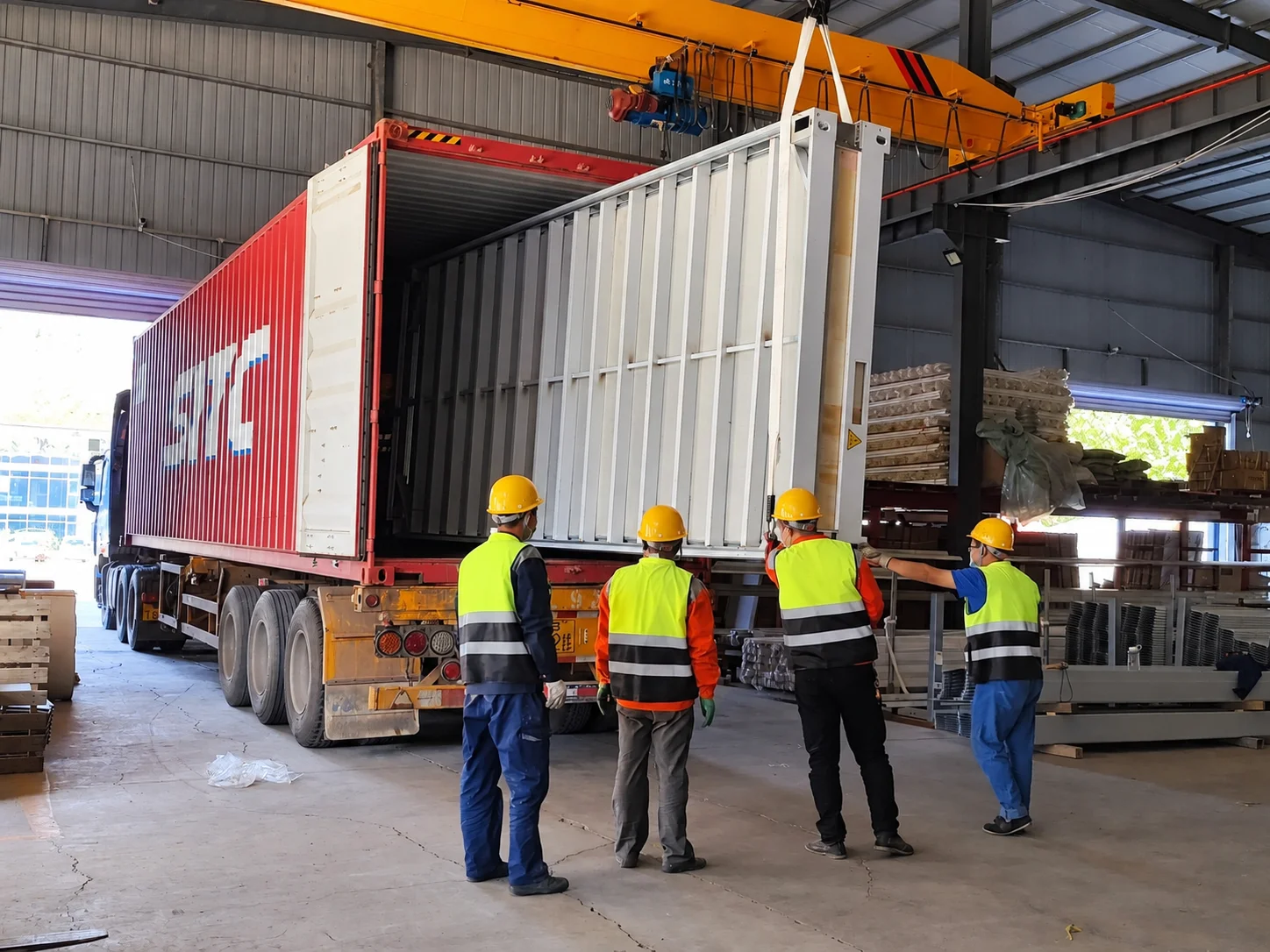 Workshop reference showing workers at the doors of a shipping container