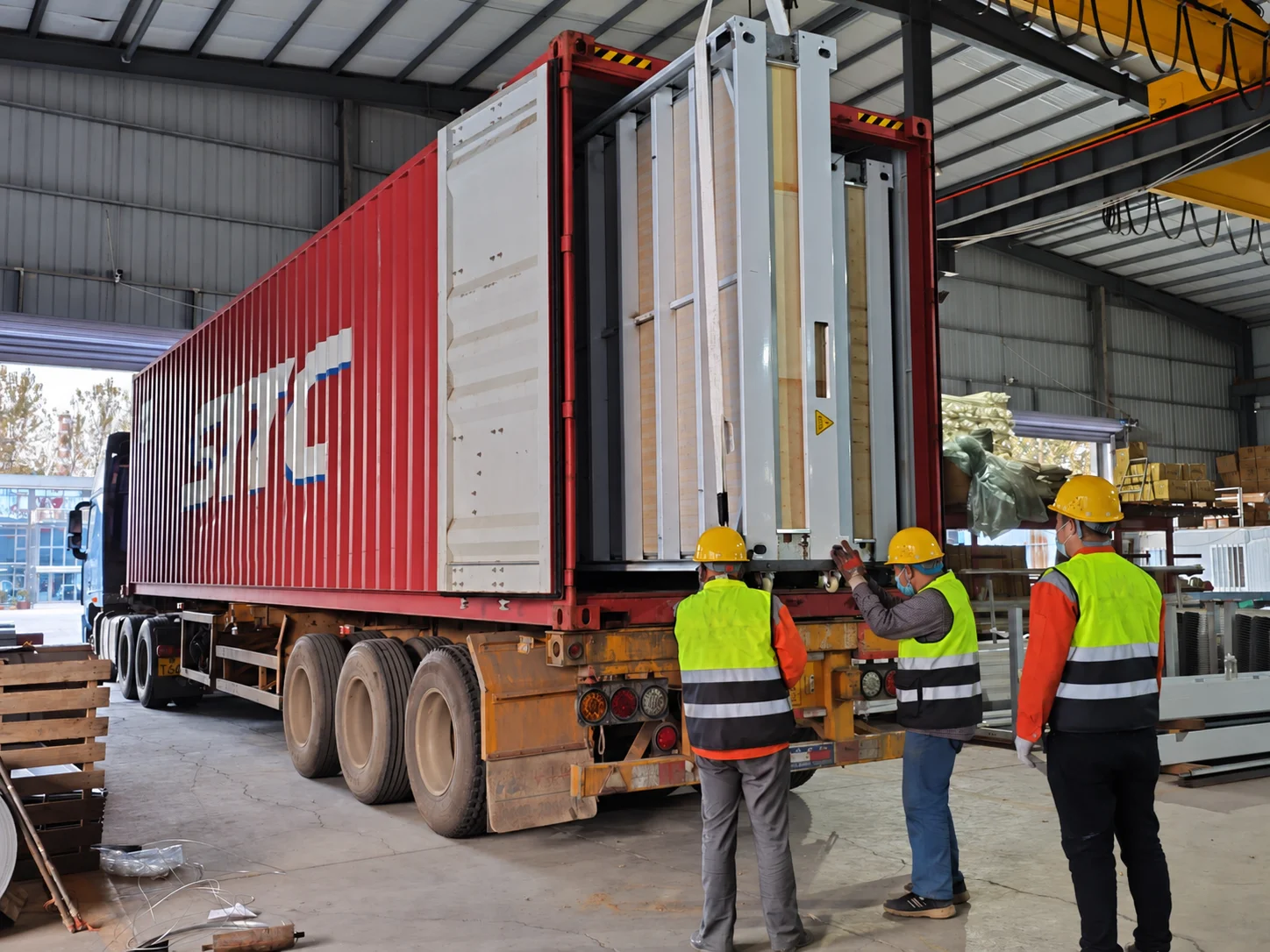Workshop reference showing a truck-mounted shipping container inside a production building