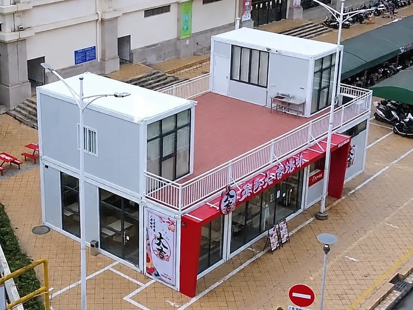 Reference stacked modular commercial building with a red ground-floor facade