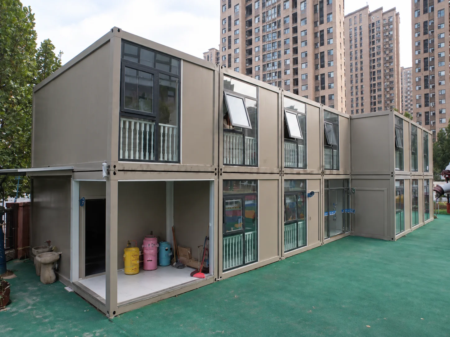 Reference grey stacked modular rooms with windows and ground-level doors