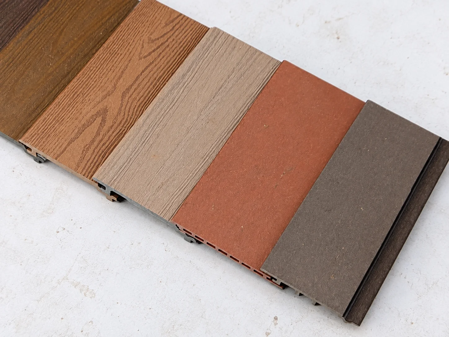 Referência do material: Amostras de painéis de acabamento em diversas cores de veios de madeira.