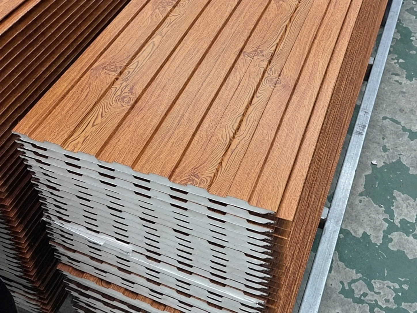 Referência de material: painéis de acabamento com padrão de veios de madeira empilhados, mostrando as camadas nas bordas.
