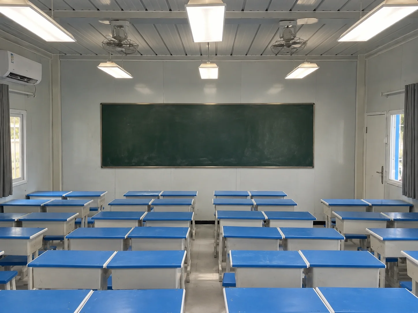 Referenzklassenzimmer mit blauen Tischen und Stühlen, die auf eine Tafel ausgerichtet sind.