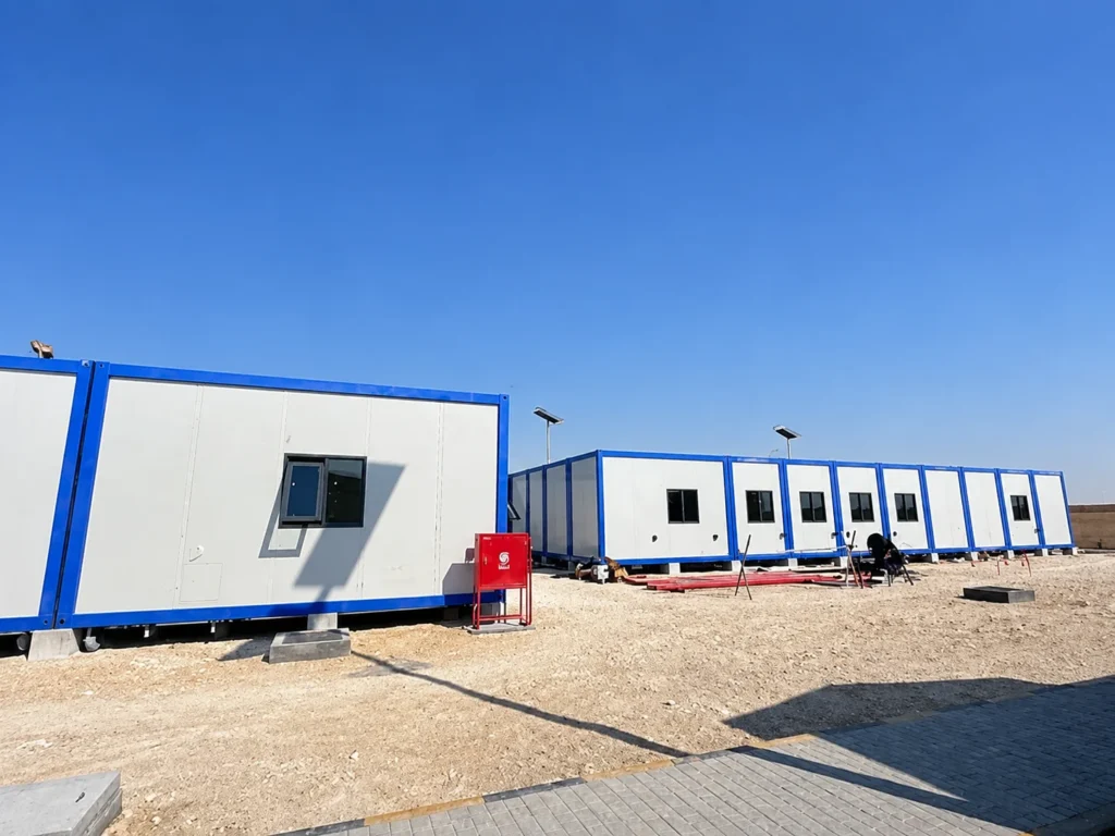 Reihe weißer Modulkabinen mit blauen Kanten am Projektstandort in Oman