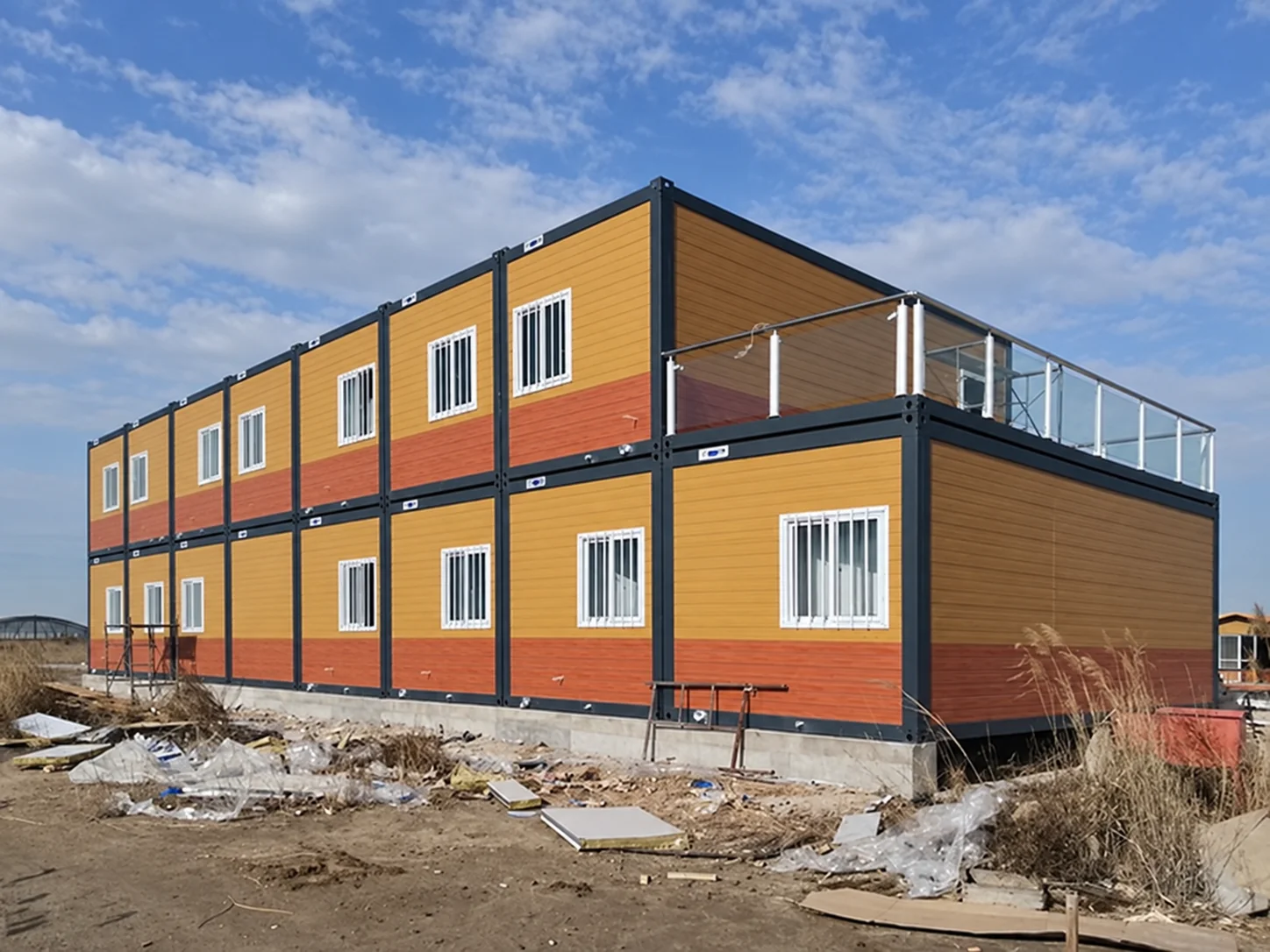 Edifício modular de dois andares com painéis de parede amarelos e laranjas no projeto da Tailândia