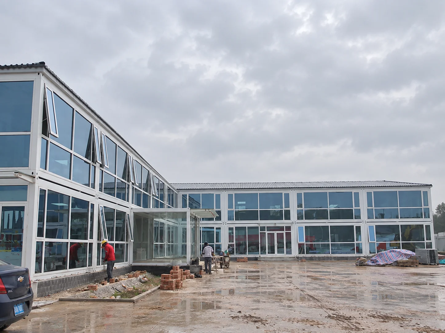 Portfólio de projetos mostrando edifícios modulares com fachada de vidro ao redor de um pátio aberto.
