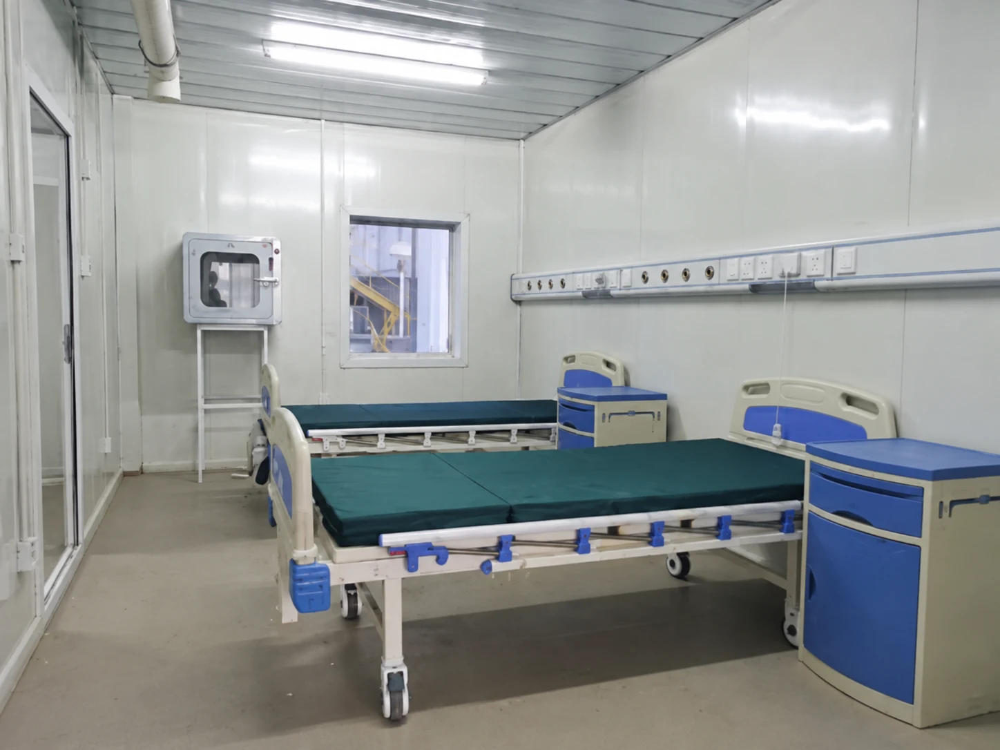 Two care beds and a wall service rail inside a modular room; wider room-use reference.