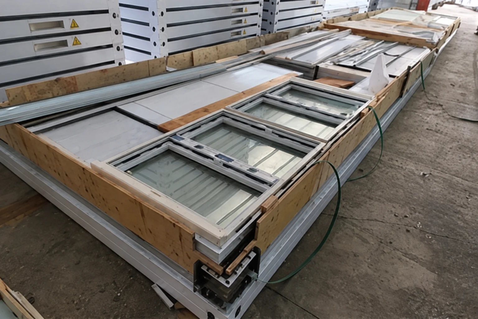 Werkstattverpackungsreferenz mit Fenster- und Türkonstruktionen, die durch einen Holzrahmen geschützt sind.