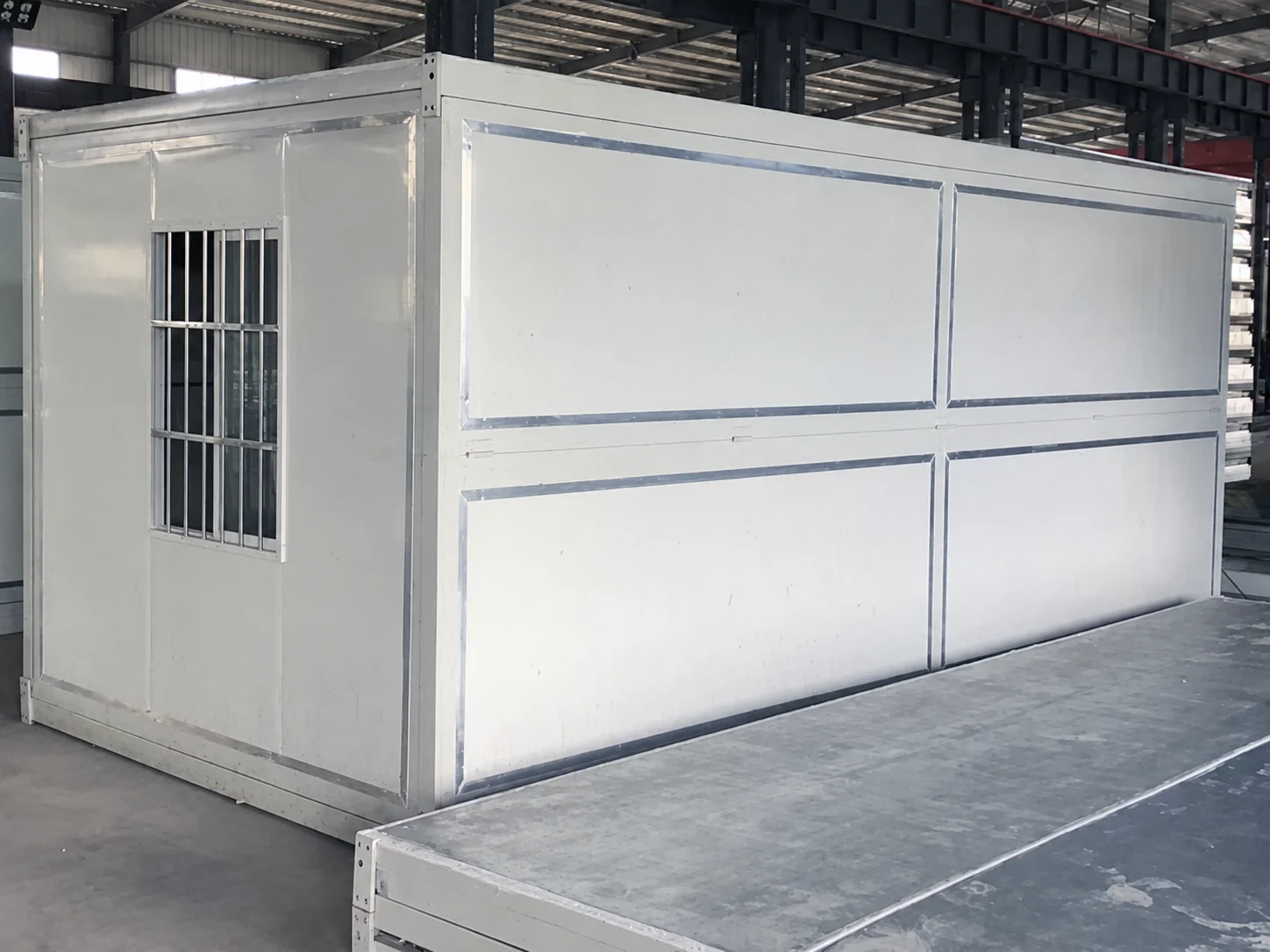 Module pliable blanc fermé sur le sol de l’atelier de production
