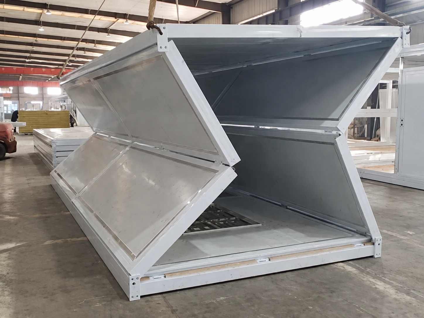 Unité modulaire pliable en état ouvert à l'intérieur d'un atelier