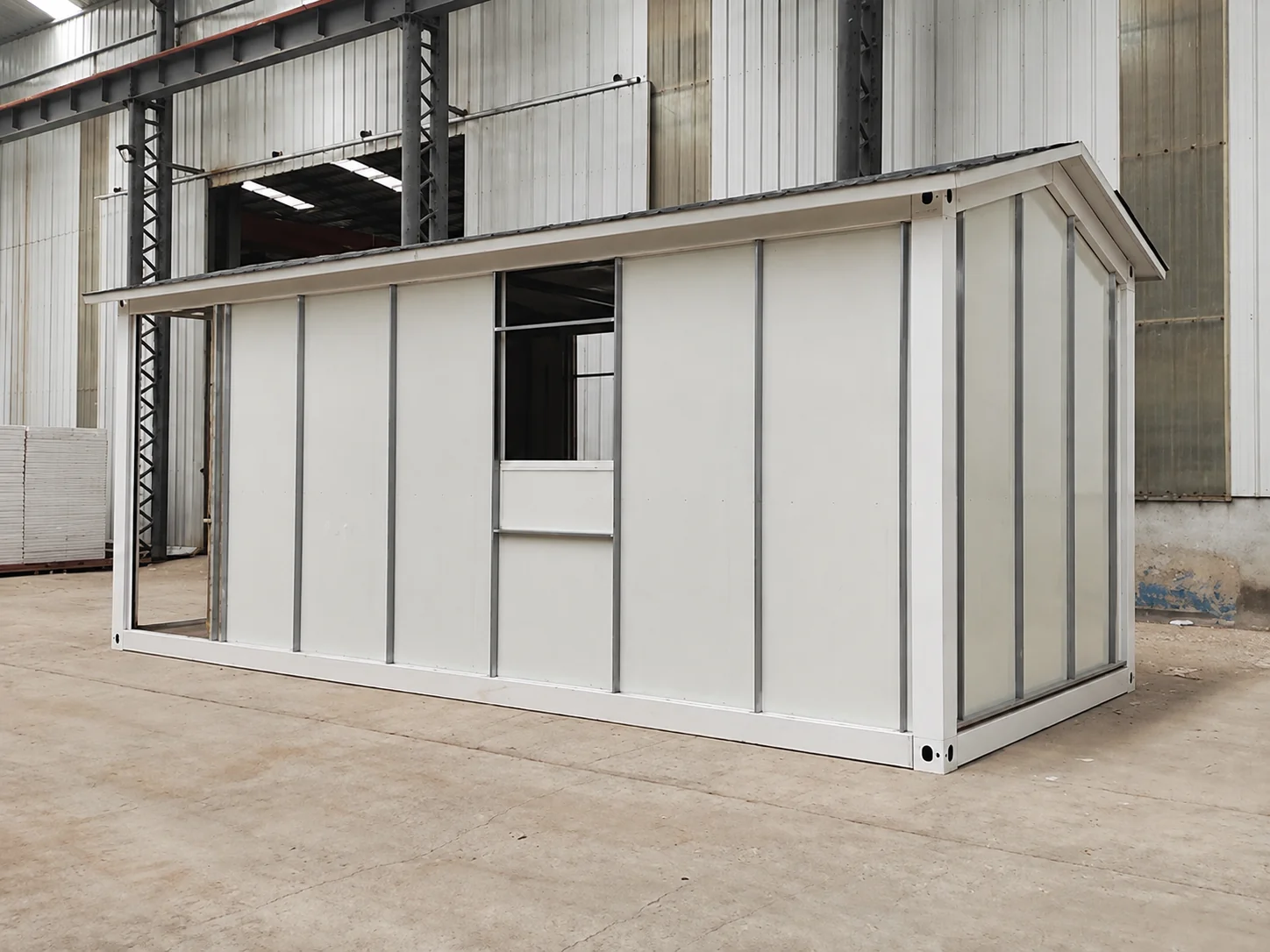 Referência de oficina mostrando uma cabine modular com trilhos de suporte de revestimento expostos.