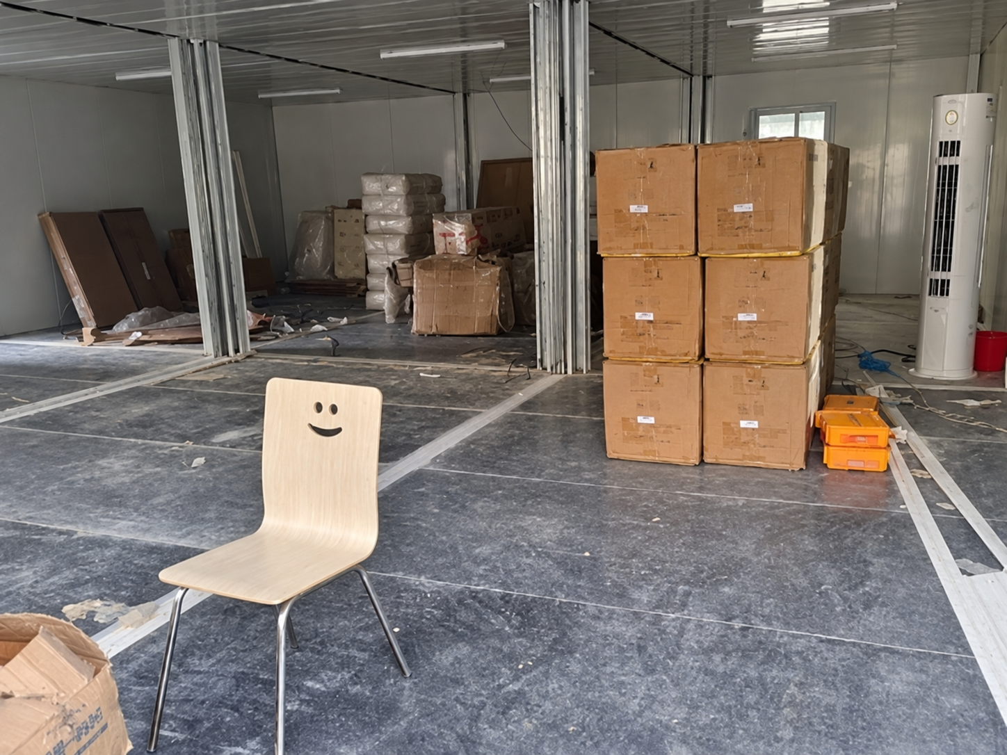Escritório interno aberto em Riade durante a fase de acabamento, com materiais aguardando instalação.