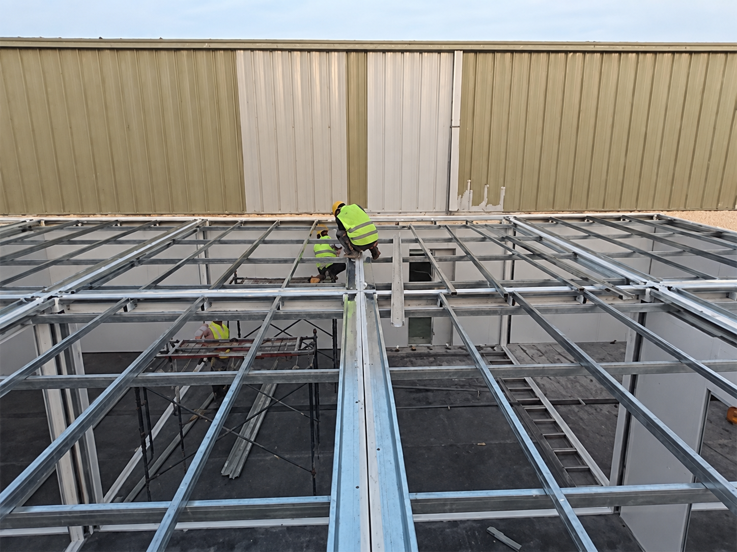 Operários montando a estrutura modular do telhado do escritório acima das unidades do térreo.
