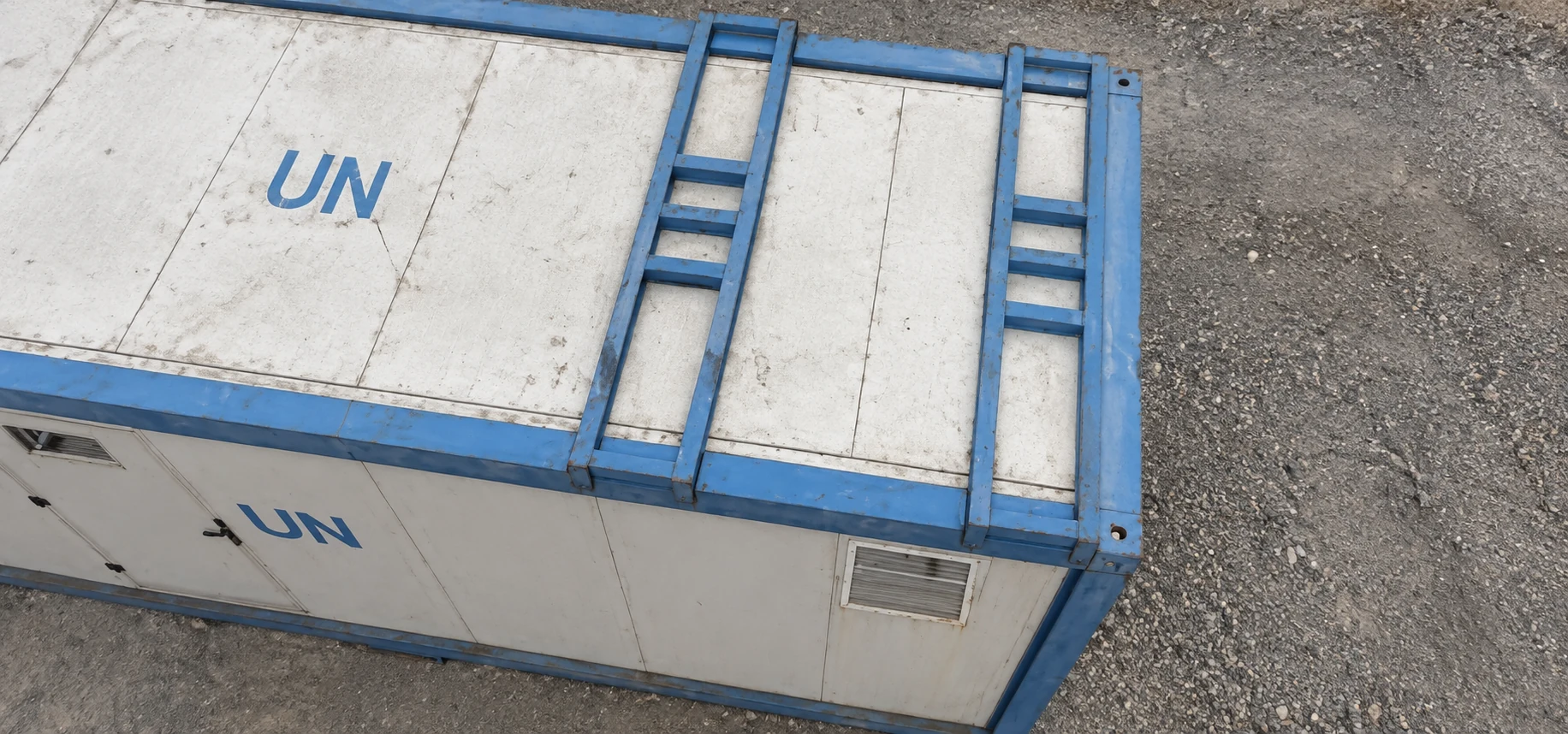Close overhead reference view of a blue-framed sanitation module roof and crossmembers.