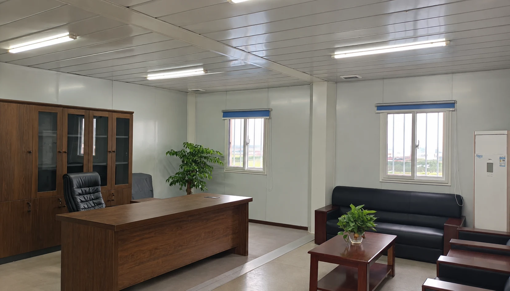 Schreibtisch aus Holz, verglaste Aufbewahrungsschränke, schwarzes Sofa und Sitzmöbel in einem modularen Büro; Interieur-Referenz.